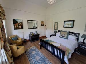 a bedroom with a bed and a desk and a chair at Country Barns Guest house in Wakkerstroom