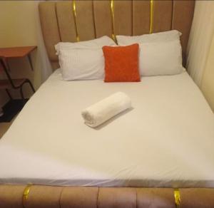 a white bed with a rolled up towel on it at Town Stays in Voi