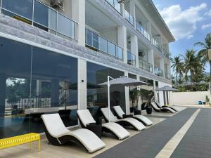 a row of white chairs and umbrellas on a building at Andante Beach Resort Batangas in San Luis