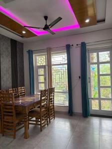 a dining room with a table and a ceiling fan at Greenvalley Homestay in Rāipur +23 photos