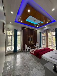 a bedroom with a large bed with a blue ceiling at Greenvalley Homestay in Rāipur