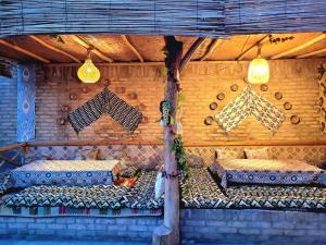 a room with two beds and lights on the wall at madrasah Polvon-Qori boutique hotel XIX century in Khiva