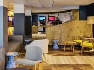 a lobby with chairs and tables and people in the background at ibis Nice Centre Gare in Nice