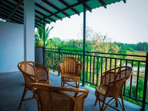 three chairs and a table on a balcony at BTI Leisure Hotel in Kataragama