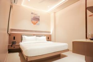 a bedroom with a white bed and a painting on the wall at DHANUSH STAYS - A Boutique Accommodation in Varanasi