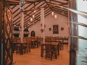 a dining room with wooden tables and chairs at BTI Leisure Hotel in Kataragama