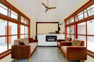 a waiting room with two chairs and a table at Collection O Vazhapadi Bus Terminal Formerly Hotel Phoenix in Salem