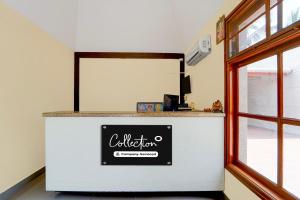 a counter with a sign on it next to a window at Collection O Vazhapadi Bus Terminal Formerly Hotel Phoenix in Salem