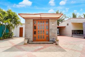 a house with a wooden door in a courtyard at Collection O Vazhapadi Bus Terminal Formerly Hotel Phoenix in Salem