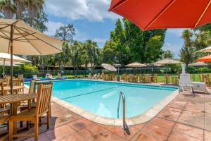 a swimming pool with chairs and umbrellas at Inn Marin and Suites, an Ascend Collection Hotel in Novato