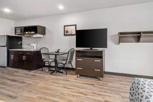 a living room with a table and a flat screen tv at WoodSpring Suites Memphis East I-40 in Memphis