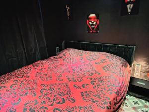 a bed with a red comforter and a mask at L'instant Désir love room jacuzzi in Ferrières