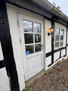 a white door and window on a house at Skelby Præstegård lej 1 in Gedser