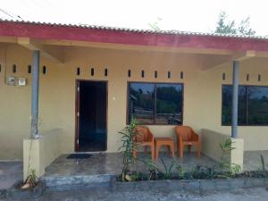a house with two chairs and a table in it at Amanda Ekas Homestay in Pulau Gilkaliantan