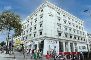 a white building on a city street with people walking in front at Victory Hotel & Spa Istanbul in Istanbul