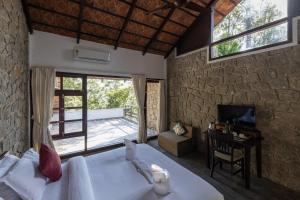 a bedroom with a bed and a stone wall at Avadale Munnar (Stag Groups Not Allowed) in Chinnakanal