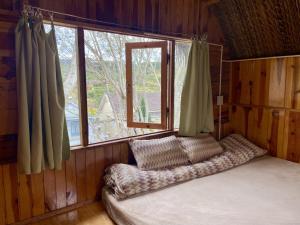 a bed in a room with a window at Đà Lạt Củi Homestay in Da Lat
