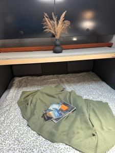 a bed with a blanket and a book on it at Berg & See Hideaway in Mitterstein
