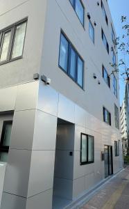 an exterior view of a white building with windows at AKATSUKI HOTEL Ueno JR山手線鶯谷駅まで徒歩3分 成田空港直行 新宿渋谷直通 in Tokyo