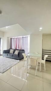 a living room with a glass table and a couch at Vida View Apartment by Vida Connect in Makassar