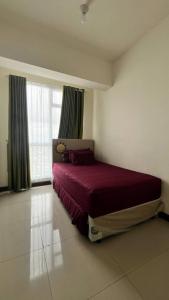 a bedroom with a large bed with a red blanket at Vida View Apartment by Vida Connect in Makassar +55 photos