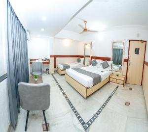 a hotel room with two beds and a chair at Hotel The Black Diamond in Bangalore +16 photos