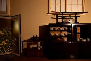 a room with a mirror and a shelf with dishes at Ryokan Suzuri 旅館 すずり in Tokyo