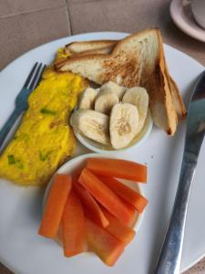 a plate of food with eggs and toast and carrots at Cherry Homestay in Kuta Lombok