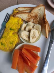 a plate of food with eggs and toast and carrots at Cherry Homestay in Kuta Lombok +7 photos