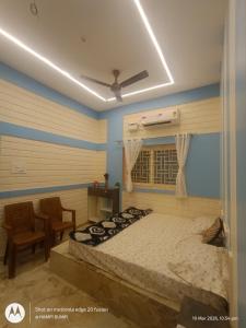 a bedroom with a bed and a chair and a window at Smarami homestay in Hospet