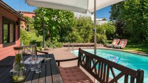 eine Terrasse mit einem Tisch und einem Sonnenschirm neben einem Pool in der Unterkunft Apartment 'Entspannen im Taunus' in Taunusstein