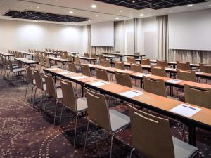 ein leerer Hörsaal mit Reihen von Tischen und Stühlen in der Unterkunft Mercure Compiègne Sud in Compiègne