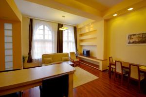 a living room with yellow walls and a table and chairs at Apartamenty Pomerius in Kwidzyn