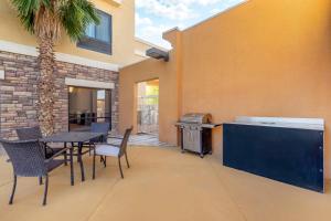 a patio with a table and chairs and a grill at Comfort Suites Blythe in Blythe