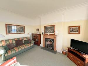 a living room with a couch and a fireplace at Ruddon Grange in Elie