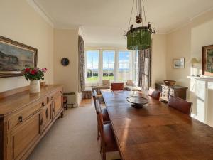 a dining room with a large wooden table and chairs at Ruddon Grange in Elie