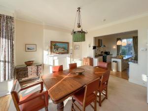 a dining room with a wooden table and chairs at Ruddon Grange in Elie +12 photos