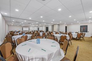 a room filled with tables and chairs with white table cloth at Quality Inn in Ottawa +33 photos