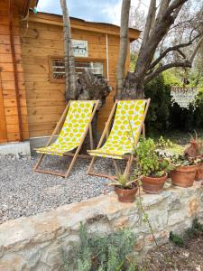 two lawn chairs in front of a cabin at Eudaimonia Wooden Suites Nafplio Kandia in Kandia