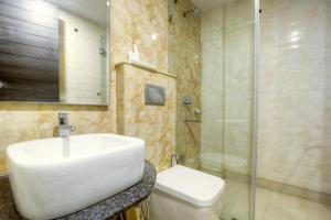 a bathroom with a white sink and a shower at Hotel Gold Souk - Karol Bagh in New Delhi