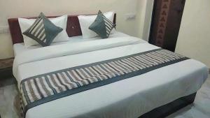 a large bed with white sheets and pillows at HoTEL DARBAR PALACE in Dewās