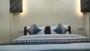 a bed with pillows on it in a bedroom at HoTEL DARBAR PALACE in Dewās +2 photos