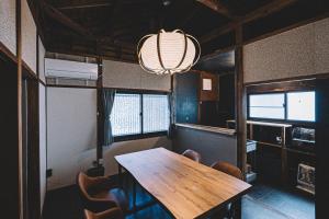 a dining room with a wooden table and chairs at 松本市の静謐と温もりあふれる隠れ家邸宅 in Matsumoto