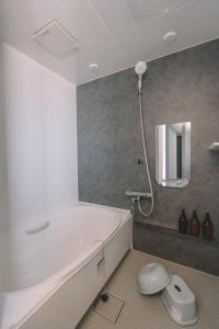 a bathroom with a white tub and a mirror at 松本市の静謐と温もりあふれる隠れ家邸宅 in Matsumoto +100 photos