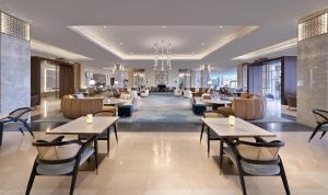 a restaurant with tables and chairs and a lobby at Sariya Hotel in Yanbu