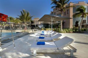 a row of white lounge chairs sitting next to a pool at Sariya Hotel in Yanbu