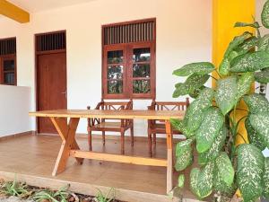 a wooden table in a room with a plant at Weligama Imal Guest House in Weligama