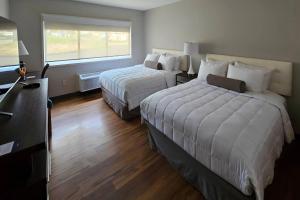 a hotel room with two beds and a window at Clarion Pointe South Portland in South Portland