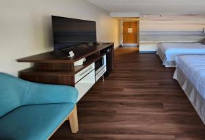 a hotel room with two beds and a flat screen tv at Clarion Pointe South Portland in South Portland