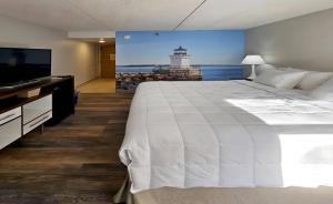 a bedroom with a large white bed and a lighthouse at Clarion Pointe South Portland in South Portland +51 photos